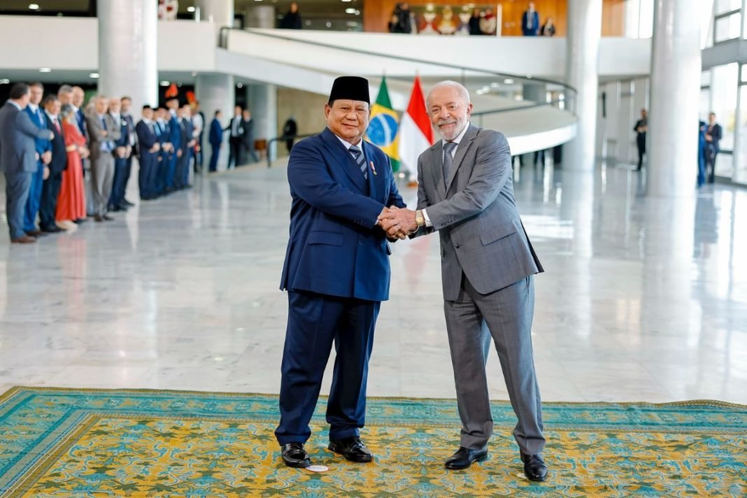 Prabowo dan Lula bersalaman sambil tersenyum di Istana Palácio do Planalto