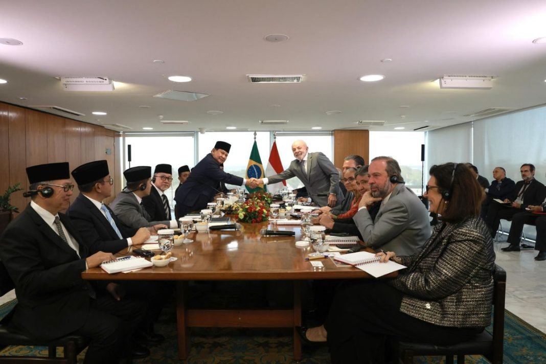 Prabowo dan Lula bersalaman sambil tersenyum di Istana Palácio do Planalto