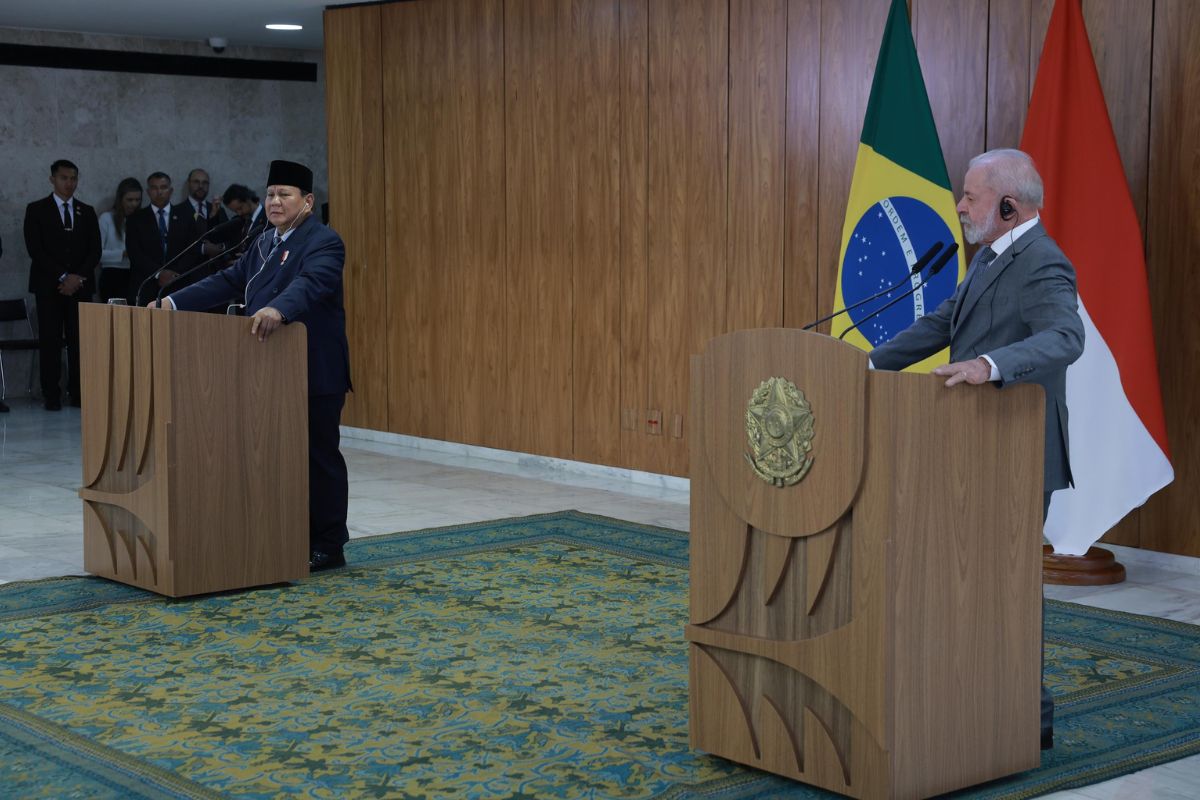 Prabowo dan Lula bersalaman sambil tersenyum di Istana Palácio do Planalto