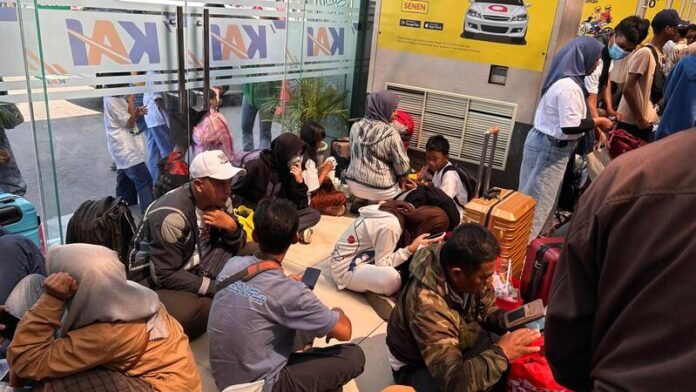 Pemudik duduk lesehan di Stasiun Pasar Senen